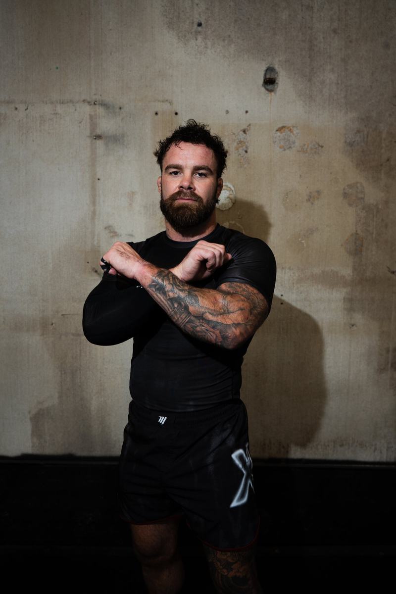 Cam Hurd with his arms crossed in front of a concrete wall