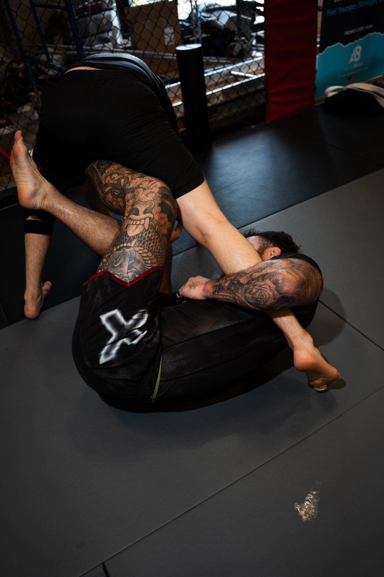 Cam working a leg entanglement on the mat