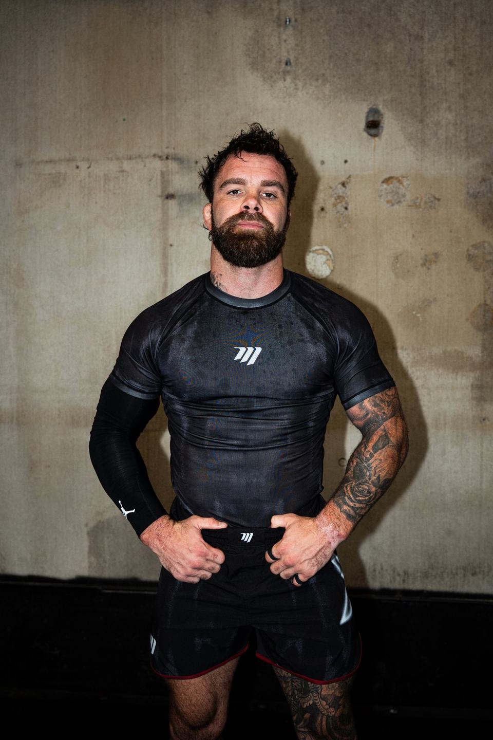Cam Hurd standing with his hands on his hips in front of a concrete wall