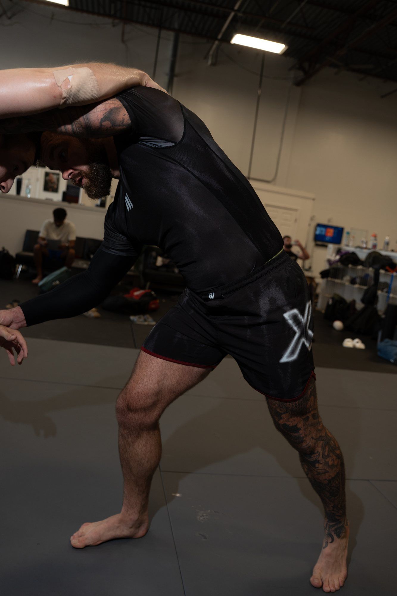 Cam dropping into a low wrestling stance on the mat